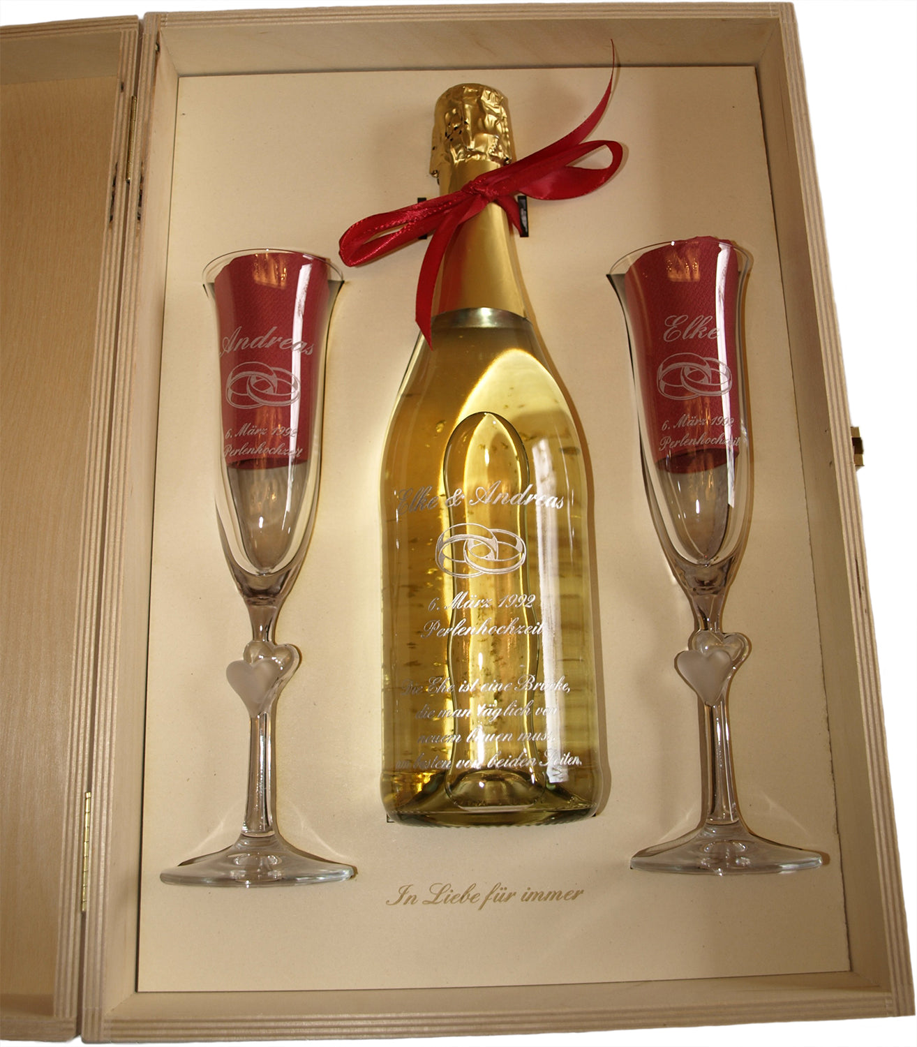 Geschenkset mit gravierter Flasche und zwei Sektgläsern in Holzbox.